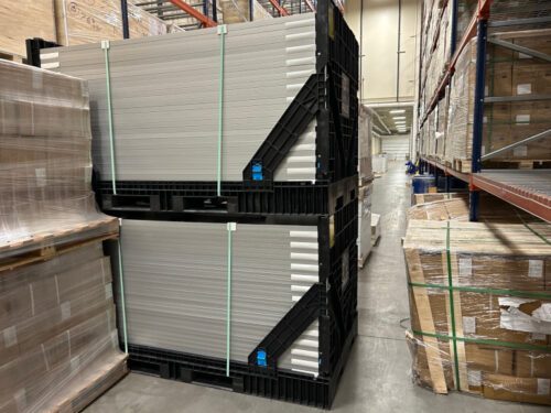 Solar panels stored in crates in a warehouse